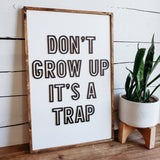 Don't grow up it's a trap wood sign